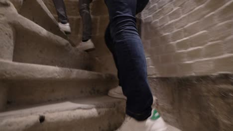 Sportive-man-climbing-spiral-stairway-with-Adidas-Stan-Smith-shoes