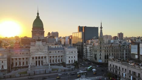 Aerial-rising-over-Monument-of-Two-Congresses-with-Argentine-Congress-Palace-in-background-at-golden-hour,-Buenos-Aires