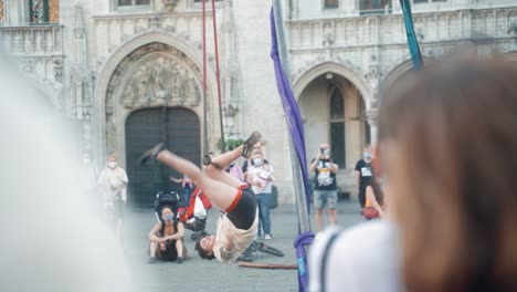 Woman-giving-acrobatic-street-performance-on-Grand-Place-of-Brussels-in-the-summer-during-covid-in-front-of-crowd