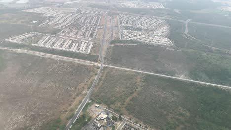 Flying-over-outskirts-and-industrial-land-of-Mexico-City,-Mexico,-aerial-wide-angle