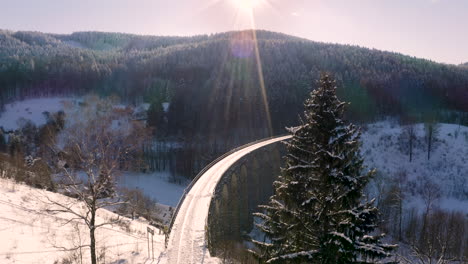 Curving-single-rail-train-viaduct-in-winter-mountains-in-evening-sun