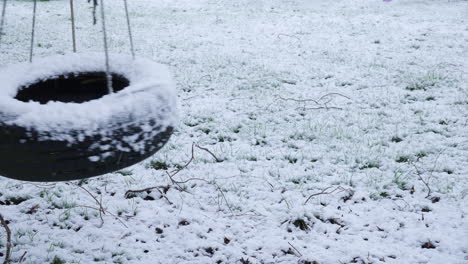 An-empty-tyre-swing-swings-in-the-snow-in-winter