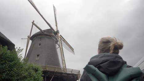 Tourism-in-the-Netherlands---A-Young-Woman-Admires-an-Old-Windmill