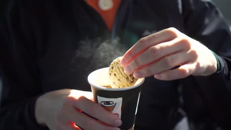 Young-beautiful-blond-hair-caucasian-woman-having-cup-of-coffee-and-cookie---Close-Up