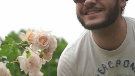 Close-up-Panning-shot-of-Guy-with-Glasses-smelling-Roses