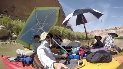 Guys-floating-together-in-canoes-on-river-in-Utah