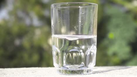 Glass-half-filled-with-water-which-is-swirling-in-slow-motion