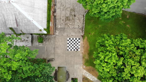 AERIAL:-Wide-Shot-Drone-Lift-Up-Above-Children-Playing-Chess-Game-Which-is-Painted-on-the-Bricks-on-the-Ground