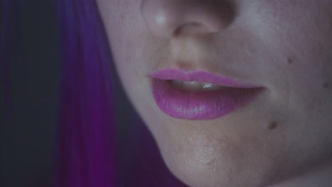 Close-up-of-a-girl's-purple-lips-in-a-dark-room