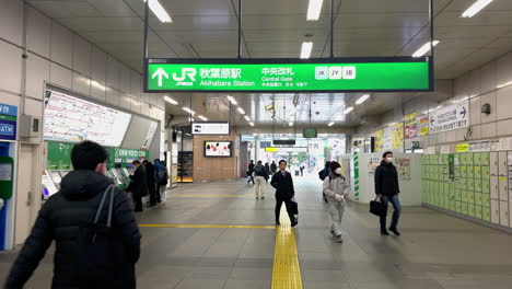 Inside-Central-gate-of-Akihabara-Station-with-passenger-walk-in-front-of-ticket-machines,-ATM-and-locker