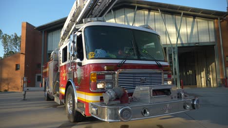 Fire-engine-sits-shiny-outside-of-a-fire-station-in-the-early-morning-sunlight