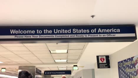 Man-entering-US-customs-where-it-says-"Welcome-to-the-United-States-of-America