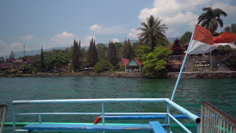 The-Indonesia-flag-blowing-in-the-wind-on-a-ferry-boat-crossing-Lake-Toba-in-North-Sumatra