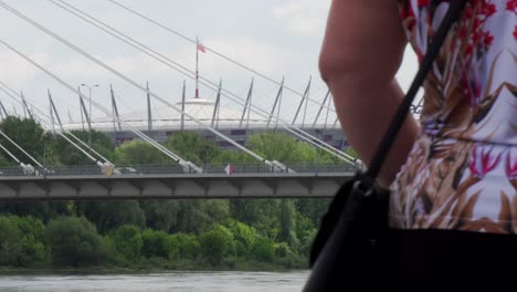 People-walking-in-a-promenade-near-the-Vistula-river-with-the-National-Stadium-of-Warsaw-in-the-back