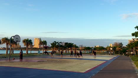 Wide-angle-View-of-adults-playing-pick-up-games-of-basketball-at-ocean-side-courts