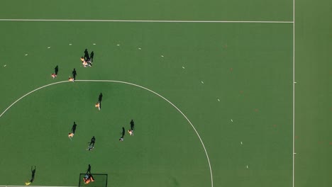 A-tracking-drone-shot-of-a-field-hockey-short-corner-goal-under-sunny-conditions