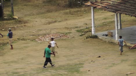 Birds-eye-view-of-Cuban-children-playing-baseball-at-dusk-on-a-dirt-square-in-a-typical-rural-town-lacking-good-infrastructure