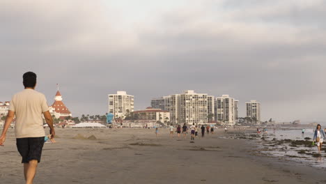 Man-Walks-Away-From-Camera-On-Coronado,-California,-Beach