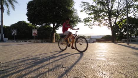 Kinder-Auf-Fahrrädern-Spielen-Bei-Sonnenuntergang-Auf-Einer-Terrasse