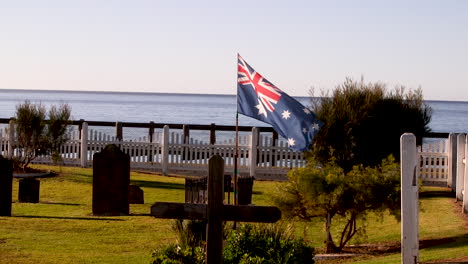 Die-Australische-Flagge-Weht-Hoch-Auf-Einem-Friedhof-Mit-Blick-Auf-Den-Ozean