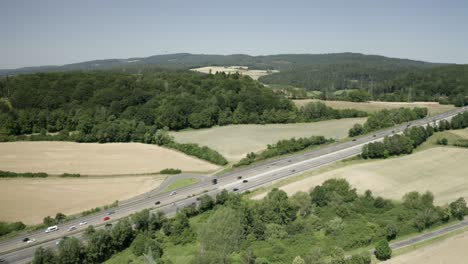 Drone-Aerial-view-of-Cars-travelling-on-the-German-Autobahn-in-harsh-sunlight,-Germany,-Europe