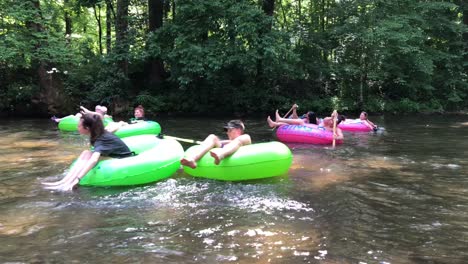 Families-tubing-on-the-Chattahoochee-River-in-Helen,-Georgia-nestled-in-the-Blue-Ridge-Mountain,-is-a-small-town-with-a-Bavarian-village-setting-reminiscent-of-Germany