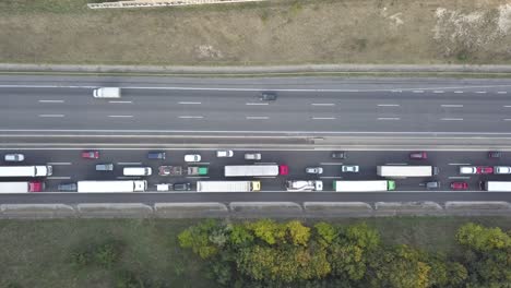 Overhead-view-of-congested-and-moving-traffic-on-six-lane-freeway,-fast