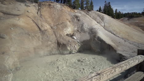 Slow-motion-of-a-boiling-muddpot-at-Lassen-Volcanic-National-Park-and-a-wooden-fence-in-the-foreground