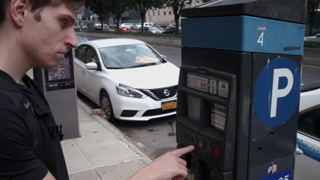 Young-Caucasian-male-swipes-credit-card-to-pay-for-parking-on-a-city-street
