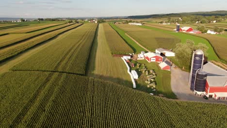 Rising-reverse-aerial-shot-of-family-farm,-hay-bales,-ag-business