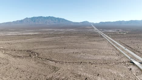 Luftaufnahme-Der-Mojave-Wüste-Aus-Großer-Höhe-Mit-Der-Interstate-15-Auf-Der-Rechten-Seite,-Die-Sich-Bis-Zum-Horizont-Erstreckt