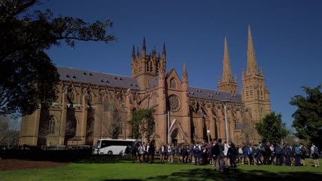 High-School-kids-assembly-in-the-park-in-front-of-a-Cathedral-on-a-sunny-day