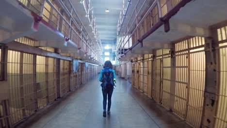 Woman-walking-in-the-middle-of-the-prison-cells-of-Alcatraz-in-San-Francisco,-USA