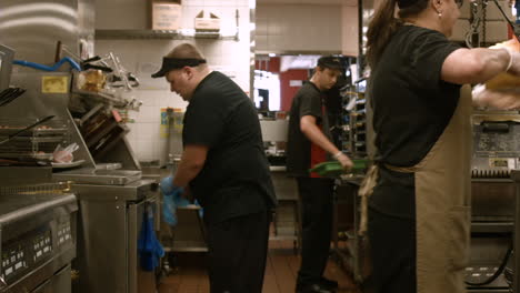 Stabilized-shot-of-McDonald's-employees-working-at-grill-and-prep-area-in-back-of-restaurant-kitchen