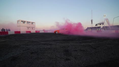 Orange-Nissan-Skyline-R34-doing-a-massive-burnout-with-pink-smoke-from-the-tyres