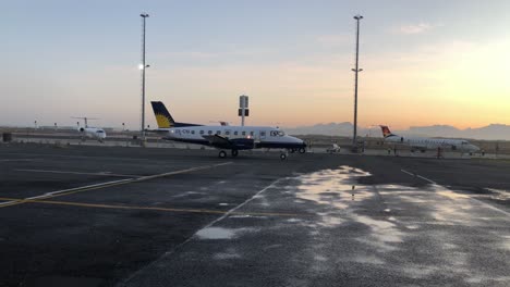 VIP-lear-jets-in-parking-postition-at-Cape-Town-International-airport-private-executive-jet-airfield-with-golden-sunset-over-Table-mountain-silhouette-and-wet-down-asphalt