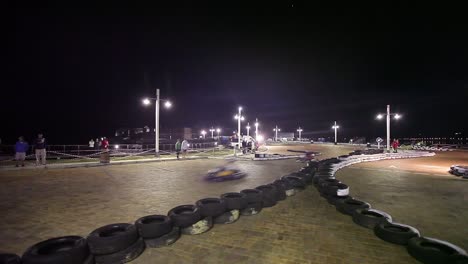 Go-carts-race-on-pavestone-street-course-at-night-in-Knysna,-S-Africa