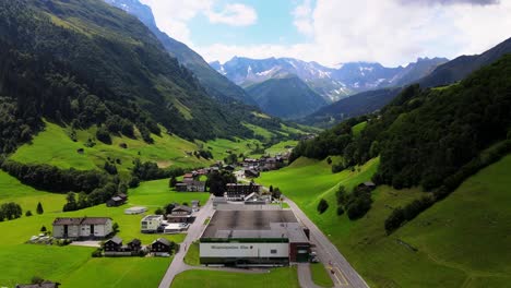 Aerial-cinematic-reveal-shot-of-Elmer-mineral-water-plant-in-Elm,-Glarus,-Switzerland