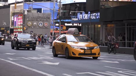 Das-Gelbe-Taxi-Von-New-York-City-Fährt-Tagsüber-In-Zeitlupe-Durch-Den-überfüllten-Verkehr-Auf-Dem-Time-Square