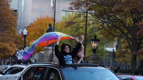 Rainbow-flag-held-by-two-people-in-a-car-at-Biden-Election-Celebration---Columbus,-Ohio
