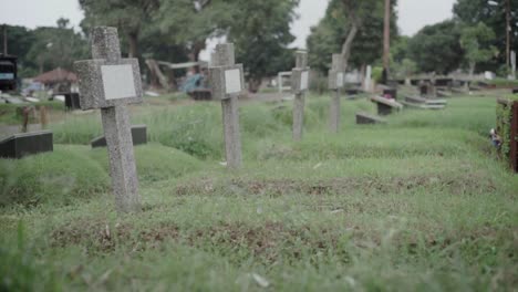 Old-stone-crosses-lined-up-in-a-row-marking-graves-at-lawn-cemetery
