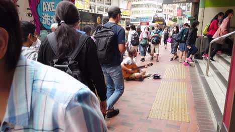 Straßenkünstler,-Der-In-Der-Innenstadt-Von-Hongkong-Gitarre-Spielt,-Während-Einheimische-Vorbeikommen