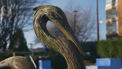 A-close-up-of-a-blue-heron-sculpture-in-the-city-landscape-with-a-blurry-background-of-buildings-blue-sky-at-fisherman's-wharf