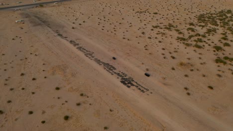 two-cars-in-the-desert,-4k-drone-video-at-salt-lake-desert-valley