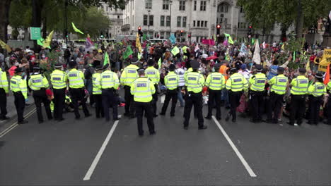 London-Metropolitan-police-officers-stand-in-line-on-a-cordon-while-policing-an-Extinction-Rebellion-climate-change-protest-that-has-blocked-the-road-outside-Parliament-in-Westminster