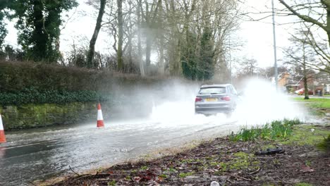 Storm-Christoph-car-driving-rainy-flooding-river-village-road-splashing-street-cones