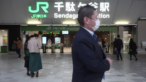 Business-Man-Wearing-Face-Mask-Passing-By-The-Sendagaya-JR-Station-In-Tokyo,-Japan