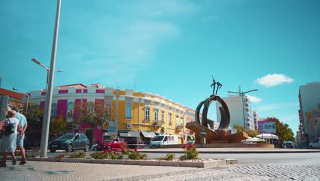 Portugal-Algarve-Loule-street-fountain-square-roundabout-with-age-couple-pedestrian,-cars-passing-by-at-morning-with-sunshine-4K