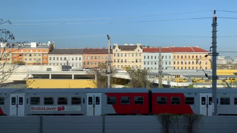Various-scenes-of-commuter-trains-passing-in-front-of-buildings-in-the-city-of-Vienna,-Austria