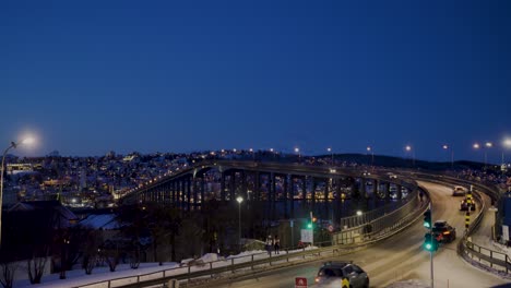 Static-wide-shot-of-cars-driving-over-bridge-in-Tromso-during-winter
